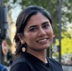 Ayushi Jain smiling in front of a nature background